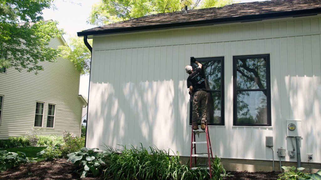 Front page Window installer of Raleigh Window Company doing finishing touches of newly installed window